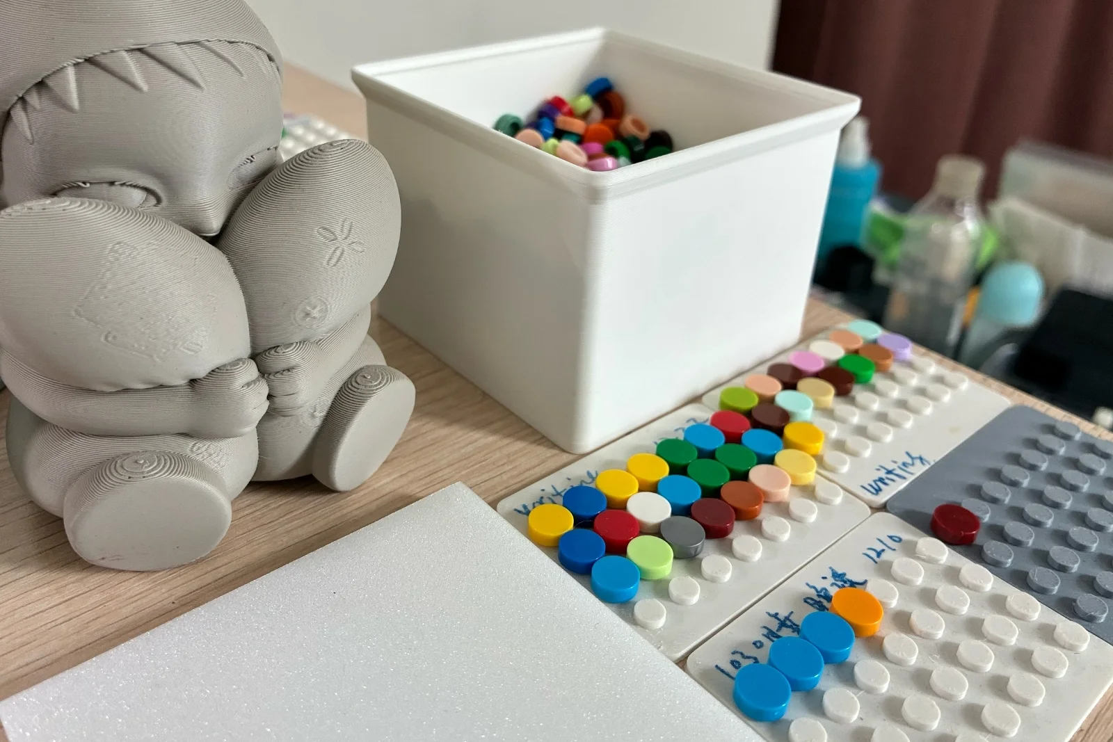 Several active baseplates and a container of colored bricks on Louis's desk.